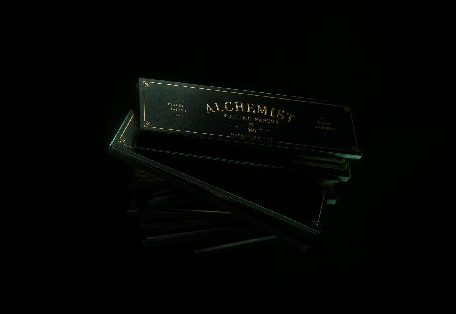 Rolling paper booklets lit in gold against a black background